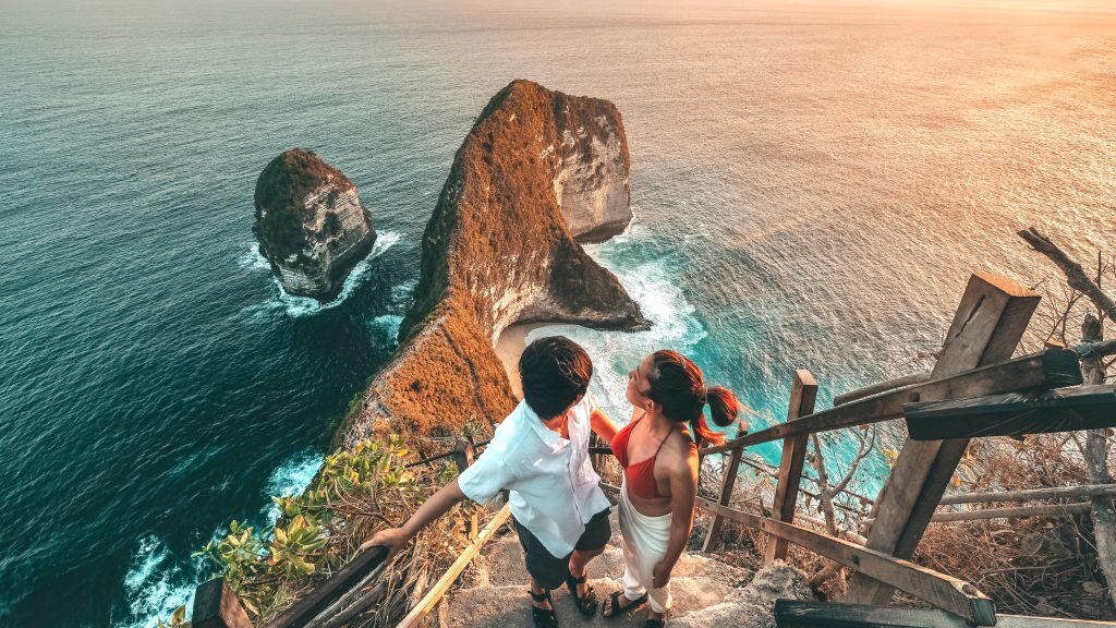 Couple Travel view of landscape with Kelingking beach, Nusa Penida island Bali ,Indonesia